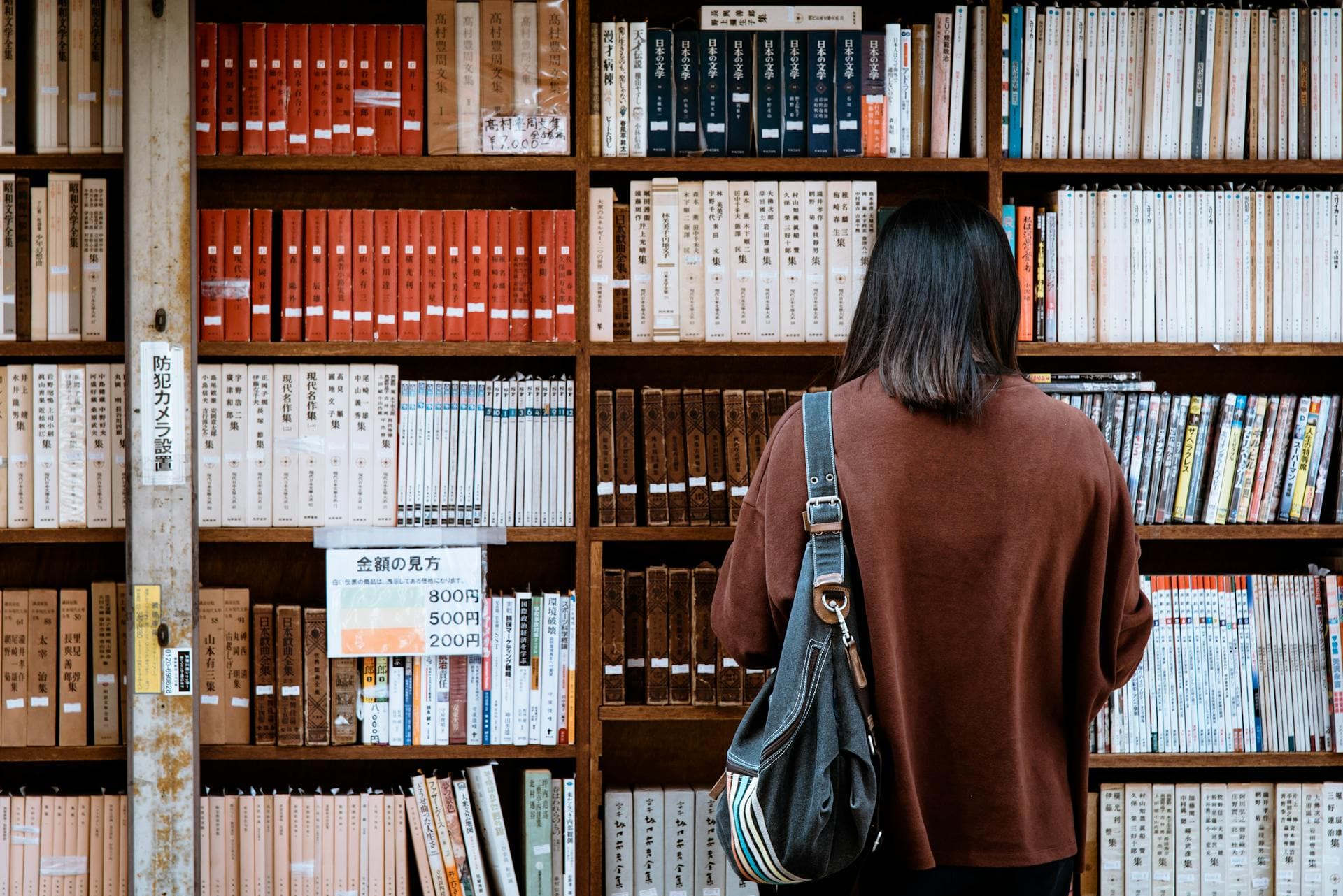 Girl reading in front of a bookshelf